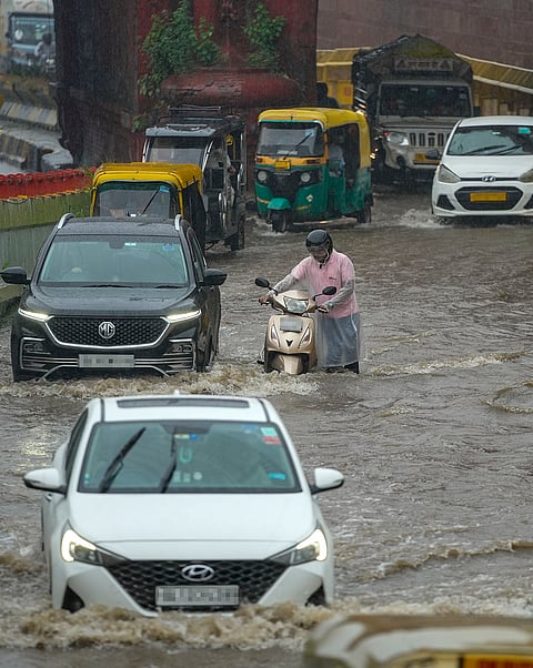 Vehicles wade through a waterlogged road amid rainfall, at Kashmere Gate, in New Delhi.