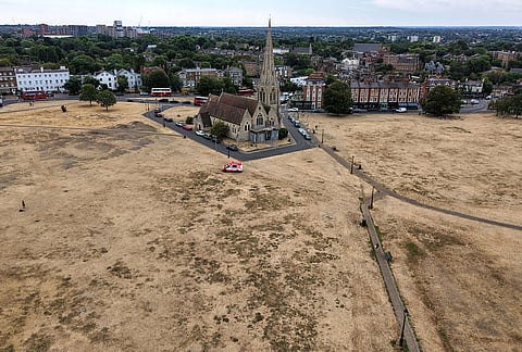 Dried vegetation is seen surrounding the All Saints church in Blackheath, London, Tuesday, Aug. 4, 2026, as the hot and very dry weather continues for most parts of the UK. 