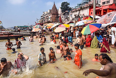 People take a dip in the swollen Ganges as the water level rises due to heavy monsoon rain, at Dashashwamedh Ghat in Varanasi district, Uttar Pradesh.