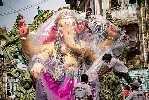 Workers cover a huge idol of Lord Ganesh as part of preparations ahead of Ganesh Chaturthi festival, in Mumbai, Maharashtra.