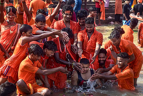 'Kanwariyas' gather as they take a dip in the Ganges ahead of the second Monday in the month of 'Shravan', at Dashashwamedh Ghat in Varanasi, Uttar Pradesh.