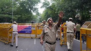 | Photo: PTI/Karma Bhutia : Police personnel block a road with barricades