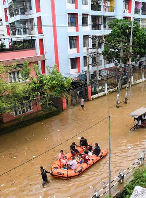 Fire and Emergency Services Department of Assam personnel rescue local residents from a waterlogged Anil Nagar area following heavy rainfall, in Guwahati.