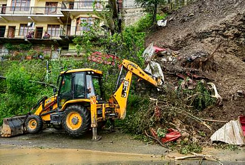 An earth mover removes debris after a landslide triggered by rainfall at Bhattakufer area in Shimla, Himachal Pradesh.