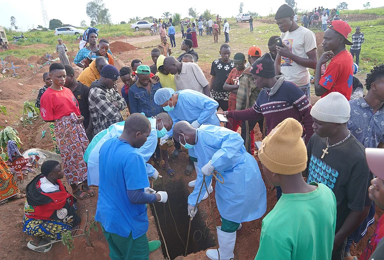 People dressed in protective gear lower into a grave the coffin containing the remains of 3-year-old Mave Mercienne, who died of Ebola, in Bunia, Ituri province, eastern Congo, Tuesday, Aug. 18, 2026. - | Photo: AP/Dieudonne Dirole