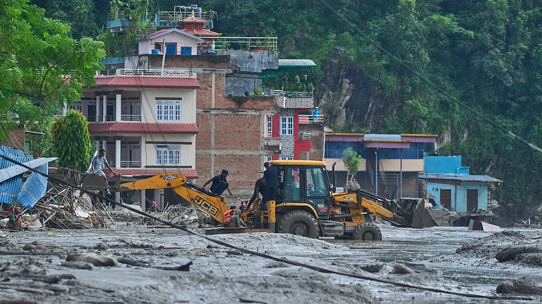 Rescuers use earthmovers to reach submerged houses after flash flooding along the Trishuli River in Nepal's Nuwakot district - AP