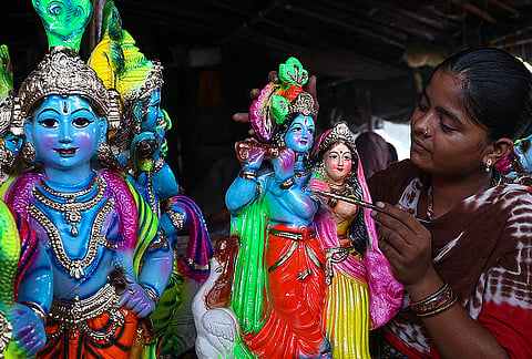 An artisan gives final touches to an idol of lord Krishna ahead of 'Krishna Janmashtami' festival, in Chennai.