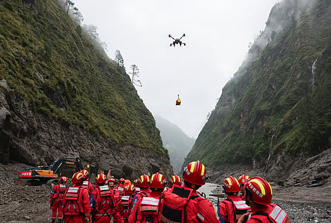 A drone carries cargo overhead as search and rescue operations are underway in a mudslide-hit area in southwestern Tibet on Saturday, August 29, 2026.