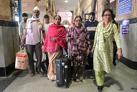Four pilgrims from the Vidarbha region, who were stranded in Nepal following the recent devastating flash floods, return at the Nagpur railway station, in Nagpur, Maharashtra.