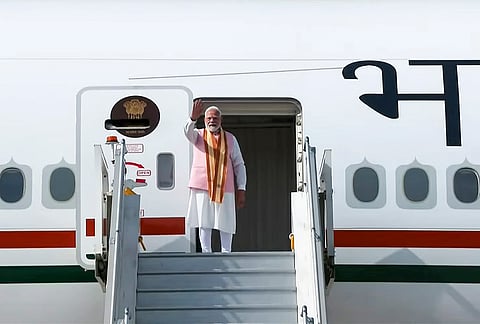 Prime Minister Narendra Modi gestures as he boards the flight for Tashkent, Uzbekistan, in New Delhi. 