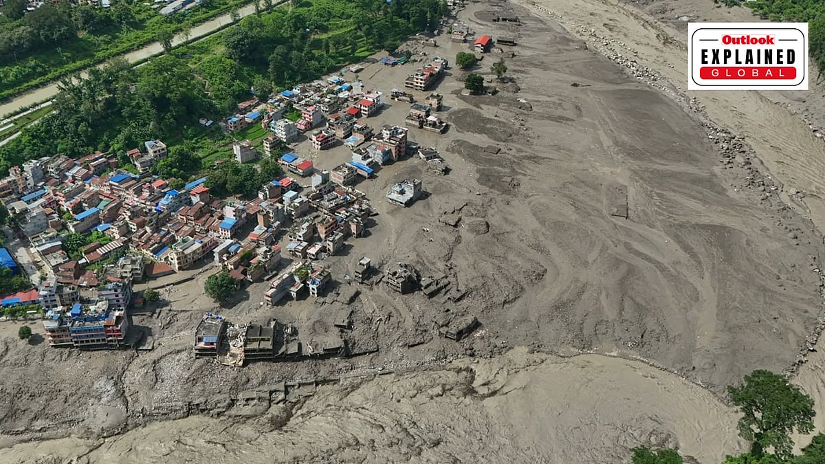 Damaged houses stand precariously near the swollen, debris-choked banks of the Trishuli River after flash floods in Nepal - AP
