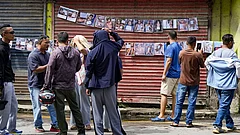 Family members look at posters displaying details of people who died in the floods, outside a hospital mortuary, in Kathmandu, Nepal. - | Photo: PTI/Arun Sharma