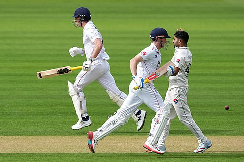 England's Harry Brook, center, and batting partner Dan Lawrence run between the wickets as Pakistan's Khurram Shahzad, right, looks on on day three of the second cricket test match between England and Pakistan in London.