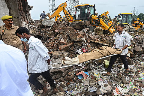 Personnel carry mortal remains after a massive explosion at a firecracker factory, in Kaushambi, Uttar Pradesh. Five people were killed in the incident.