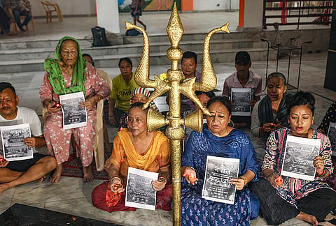 Gorkha community members hold placards as they express solidarity with flood-hit-nepal victims during a prayer meet, at a temple, in Jammu.
