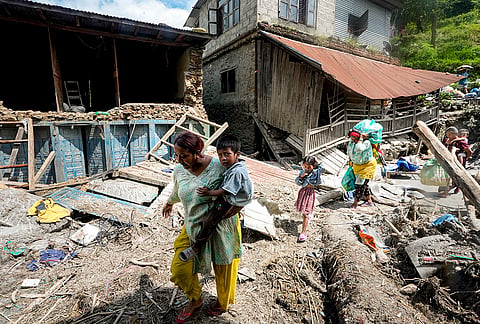 People carrying relief material move to a safer place in the aftermath of the recent flash floods, in Galchhi, Dhading district, Nepal, Sunday, Aug. 30, 2026. 