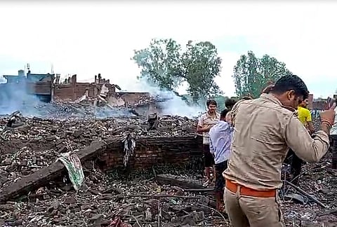 A police official at the site after an explosion in a firecracker factory, in Pipri area, Kaushambi.