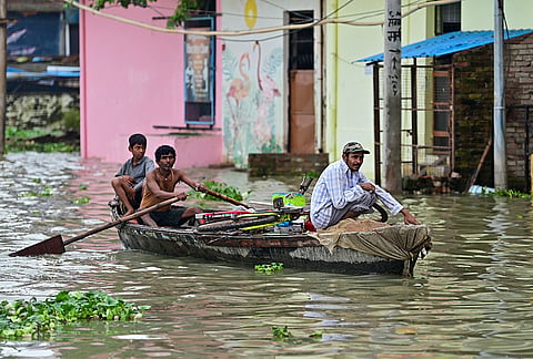 People move to a safer place on a boat after the water level of the Ganga river rises amid monsoon rains, in Prayagraj.