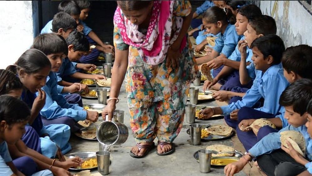 Children eat their mid-day meal seated in rows at a government school | Representational image - null