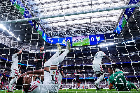 Real Madrid's Kylian Mbappe falls into the goal during the La Liga soccer match between Real Madrid and Malaga in Madrid, Spain.