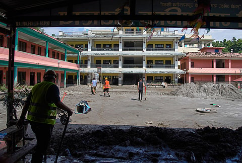 Volunteers work to remove the mud brought in by the recent flash floods from a school compound of the Shree Bagheswori Madhyamik School in Galchhi, Dhading district of Nepal Sunday, Aug. 30, 2026. 