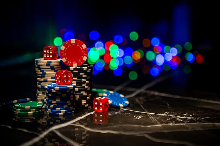 Poker chips and red dice on a dark table