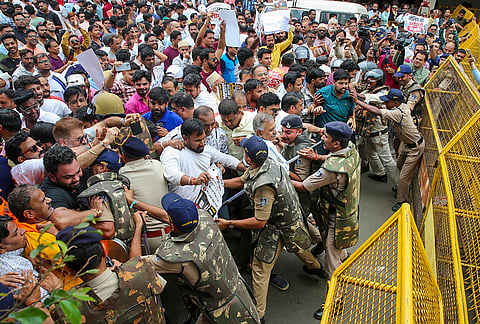Police stop traders during a protest against the sealing action by the Bhopal Municipal Corporation (BMC) for commercial activities in residential areas, in Bhopal.