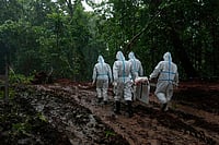 | Photo: AP/Dar Yasin : Nepal's paramilitary force personnel carry the body of a flash flood victim for burial at a mass burial site in Chitwan, Nepal.