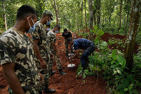 Nepal's paramilitary force personnel arrange numbered identification tags in pots to mark the graves of flash flood victims at a mass burial site in Chitwan, Nepal.