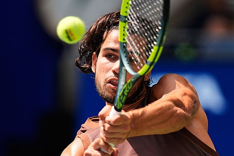 Carlos Alcaraz, of Spain, returns the ball to Roman Safiullin, of Russia, during the first round of the U.S. Open tennis championships  in New York.