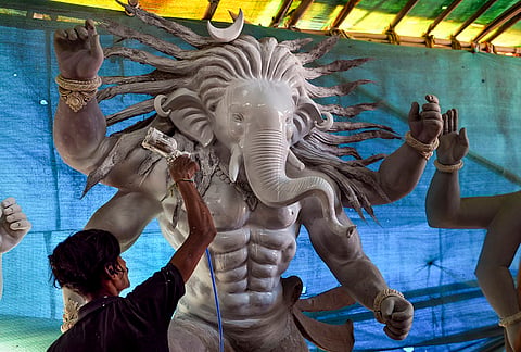 Workers apply clay to idols of Lord Ganesha to make eco-friendly idols ahead of the Ganesh Chaturthi festival, in Ahmedabad, Gujarat.