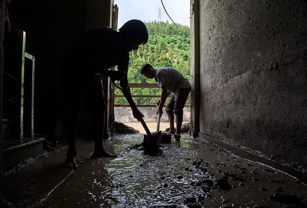 Cleaning mud and sand from flooded houses