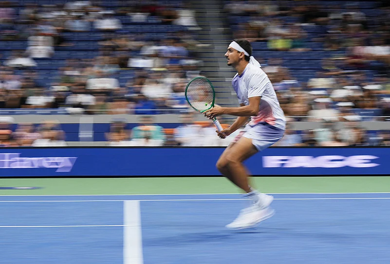 In this image taken with a slow shutter speed, Lorenzo Sonego, of Italy, rushes the net during the fourth set against Alexander Zverev, of Germany, in the first round of the U.S. Open tennis championships early Wednesday, Sept. 2, 2026, in New York.