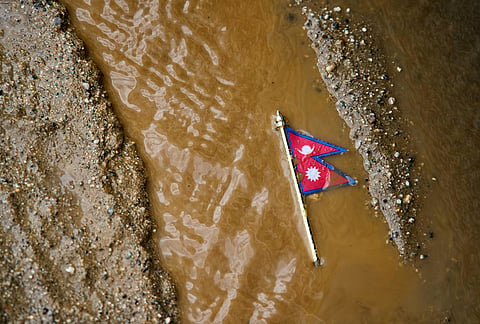 A Nepal flag lies on a muddy track near the banks of the Trishuli river in Dhading District, Nepal, Sunday, Aug. 30, 2026. 
