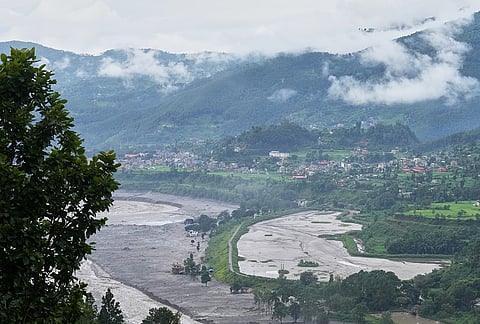 Structures partially submerged in mud brought in by flash floods stand at the banks of the Trishuli river in Nepal's Nuwakot district, Thursday, Sept. 3, 2026. 