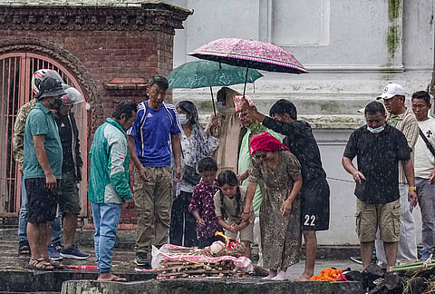 Family members perform rituals amid rain during symbolic funerals of their loved ones, who are flood victims still reported missing, in accordance with Nepali Hindu rites, at Pashupatinath temple in Kathmandu, Nepal.