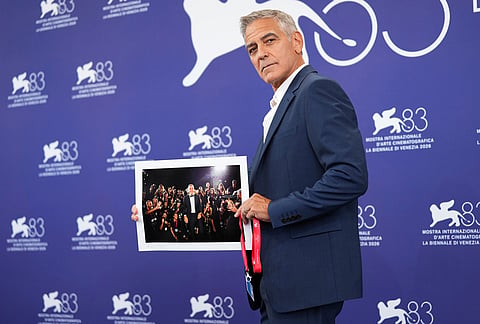 George Clooney holds a photograph, which was taken at the 82nd edition of the Venice Film Festival, presented to him by the photographers during the golden lion for lifetime achievement photo call during the 83rd edition of the Venice Film Festival in Venice, Italy, on Wednesday, Sept. 2, 2026. 