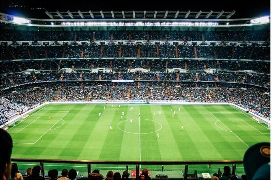 Football stadium filled with fans and a green field