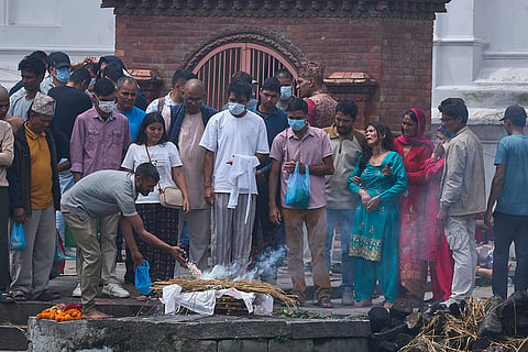 The wife of Bishi Pandey, missing in the flash floods cries next to his effigy during a symbolic funeral on the banks of the Bagmati River near Pashupatinath Temple in Kathmandu, Nepal.