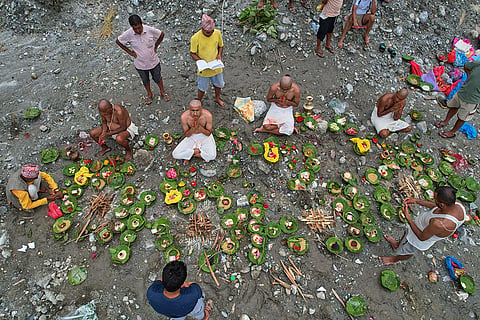 People whose relatives remain missing following flash floods perform rituals after symbolic funeral rites on the banks of the swollen Trishuli River in Nepal's Nuwakot district.