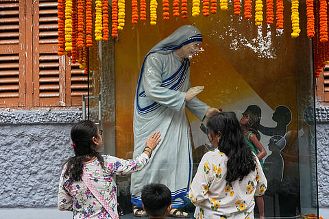 Catholics pray in front of a statue outside of the Missionaries of Charity, the order founded by Saint Teresa, on the anniversary of the saint’s death, in Kolkata, India.