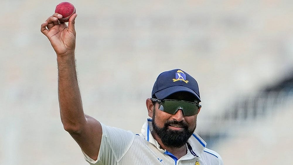 Bengal pacer Mohammed Shami holds up the ball in celebration after claiming a five-wicket haul on the fourth day of the Ranji Trophy match against Gujarat, at Eden Gardens, Kolkata. - Photo: PTI/Swapan Mahapatra