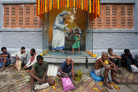 People wait in a queue to collect free food before its distribution on the death anniversary of Mother Teresa, at the Missionaries of Charity, in Kolkata, West Bengal.