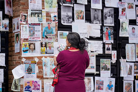 Family members look at posters of recovered and missing victims pasted outside Tribhuvan University Teaching Hospital (TUTH) amid a search operation in the aftermath of the devastating flash floods, in Kathmandu, Nepal.