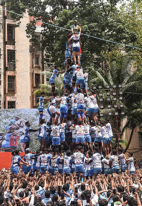 People form a human pyramid to break the 'Dahi Handi', an earthen pot filled with curd hanging above them, as part of the 'Janmastami' festival celebrations, in Mumbai, Maharashtra, Saturday, Sept. 5, 2026. 
