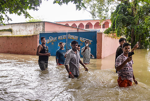 People wade through floodwaters following a rise in the water level of the Ganga river, at Nakta Diyara, in Patna, Bihar, Saturday, Sept. 5, 2026. 