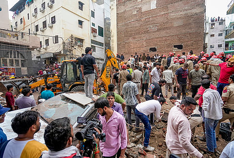 People gather on site after a five-storey building collapsed at Satya Niketan area, in New Delhi, Sunday, Sept. 6, 2026. 