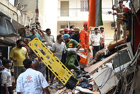 Rescue workers look for the trapped survivors under the debris of a building that collapsed in New Delhi, India, Sunday, Sept. 6, 2026. 