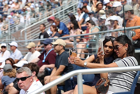 Spectators document their drinks while attending the match between Madison Keys, of the United States, and Zheng Qinwen, of China, during the third round of the U.S. Open tennis championships Saturday, Sept. 5, 2026, in New York. 