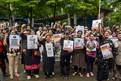 People hold placards as they stage a protest against the 'Thane Integral Ring Metro Rail Project', in Thane, Maharashtra.